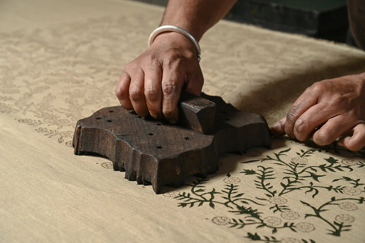 A stack of 220 GSM solid linen and block-printed cotton fabric rolls, showcasing the heavy drape and vibrant mineral-dyed colors for professional textile projects.