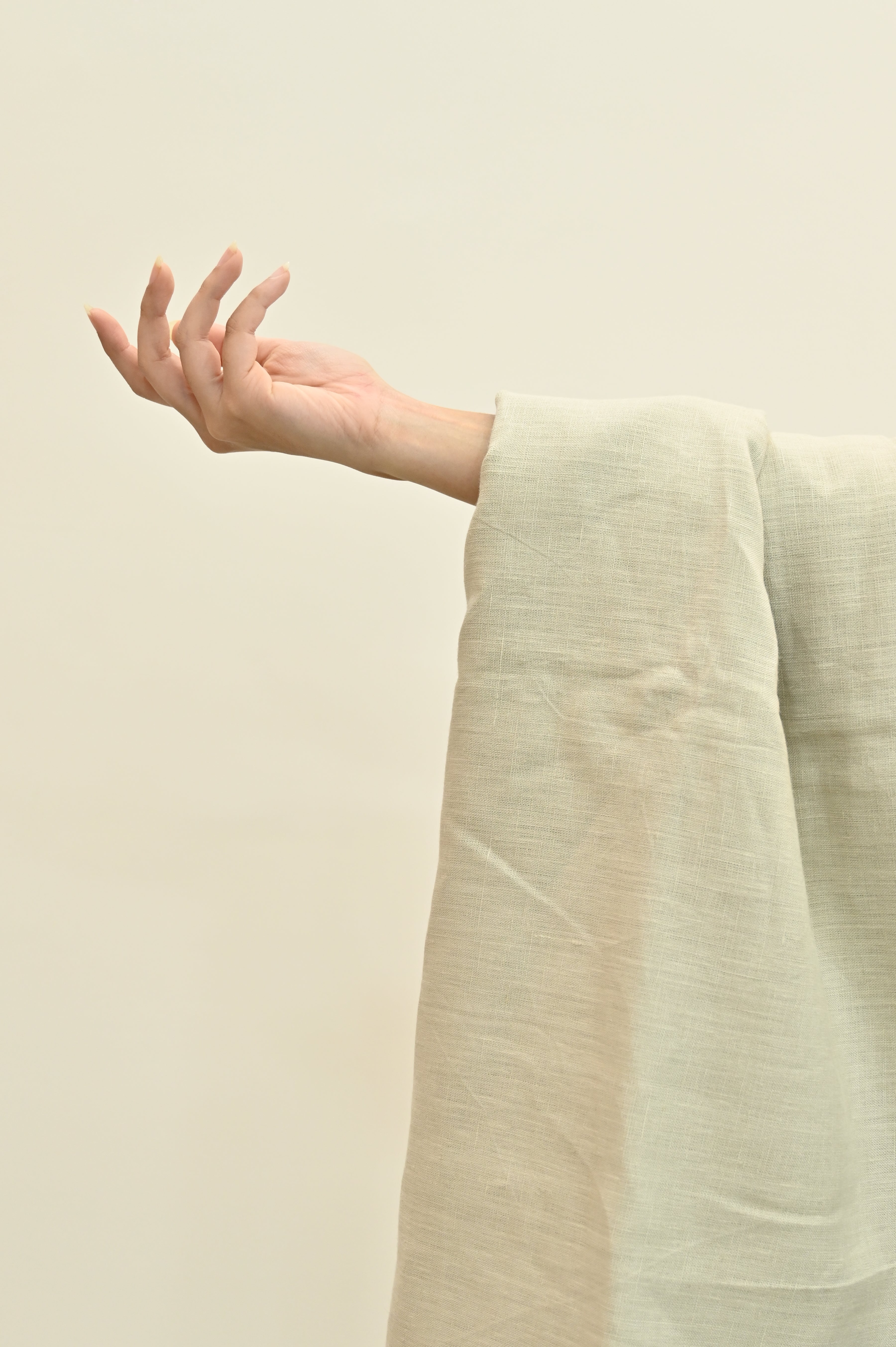 Close-up of 220 GSM solid linen in 'Sand,' highlighting the natural flax fibers and the opaque, professional-grade weave.