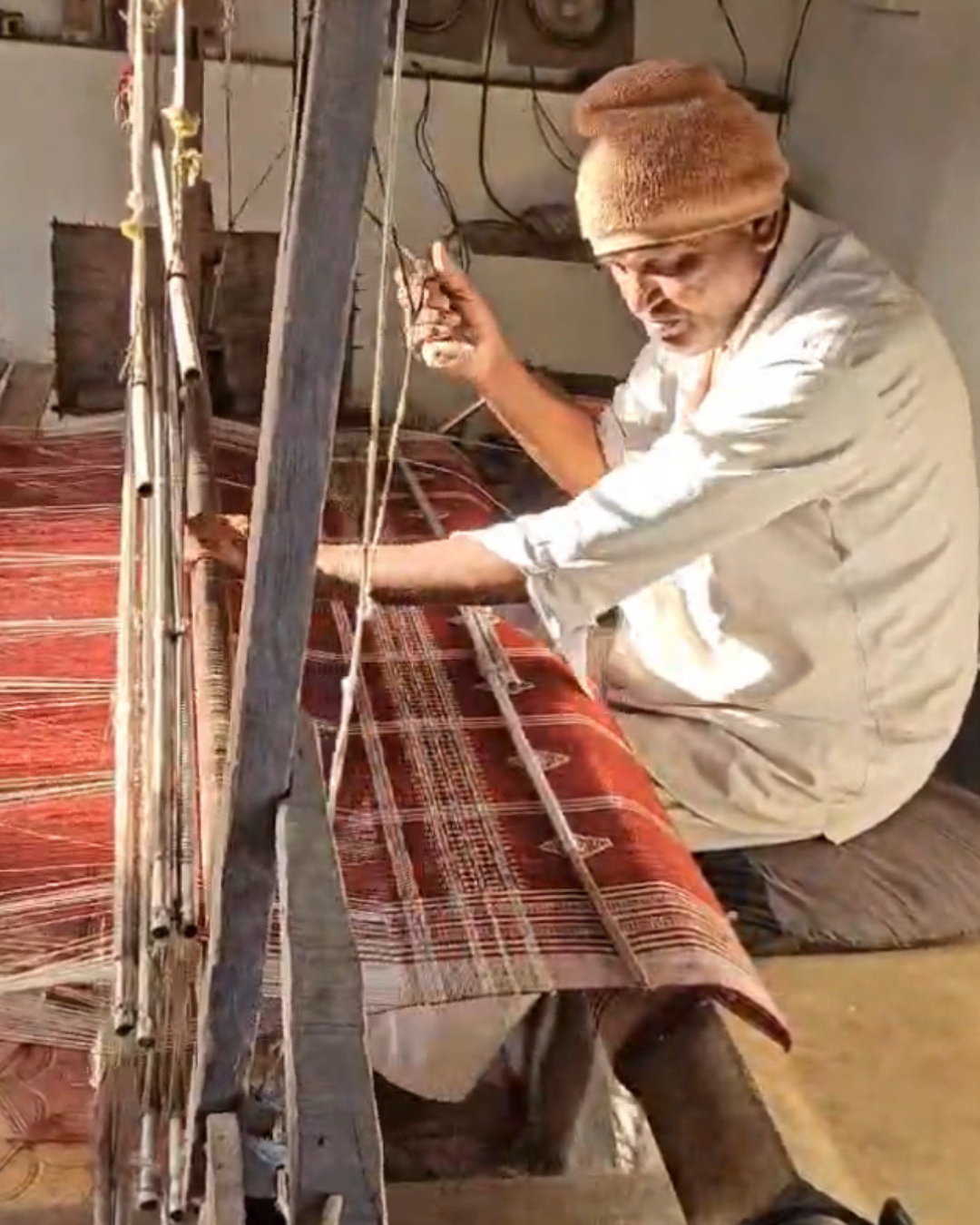 Artisan Vankar weaver in Bhujodi, India, hand-weaving a heritage wool blanket using a traditional wooden pit loom and the extra-weft geometric technique for Thread to Form.