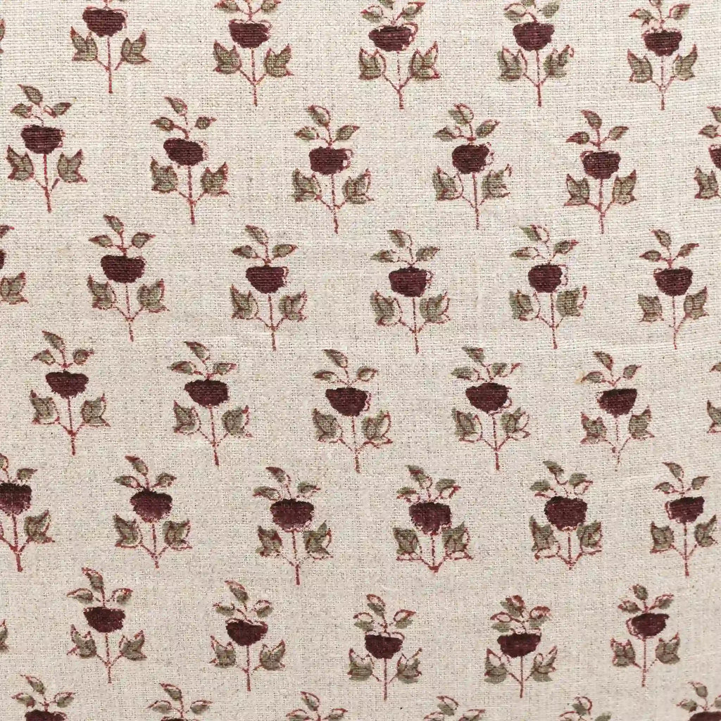 Hand block printed natural linen pillow cover featuring a plum and red floral buti motif on a textured neutral ground.