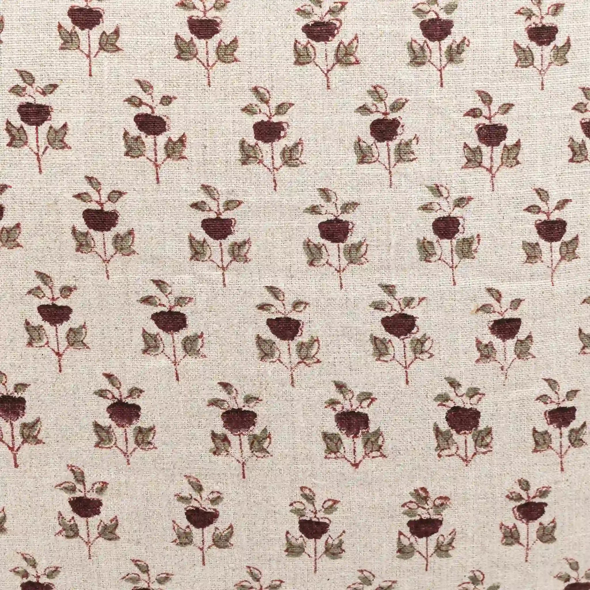Hand block printed natural linen pillow cover featuring a plum and red floral buti motif on a textured neutral ground.