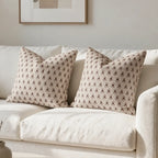 Two hand-block printed linen pillow covers featuring plum and red floral buti motifs on a natural ground.