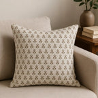 Natural linen pillow cover featuring a hand-blocked blush pink and olive green ditsy floral buti print on a sofa.