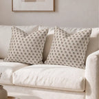 Hand block printed linen pillow covers in natural, ice blue, and plum wine ditsy floral buti pattern on a white sofa.