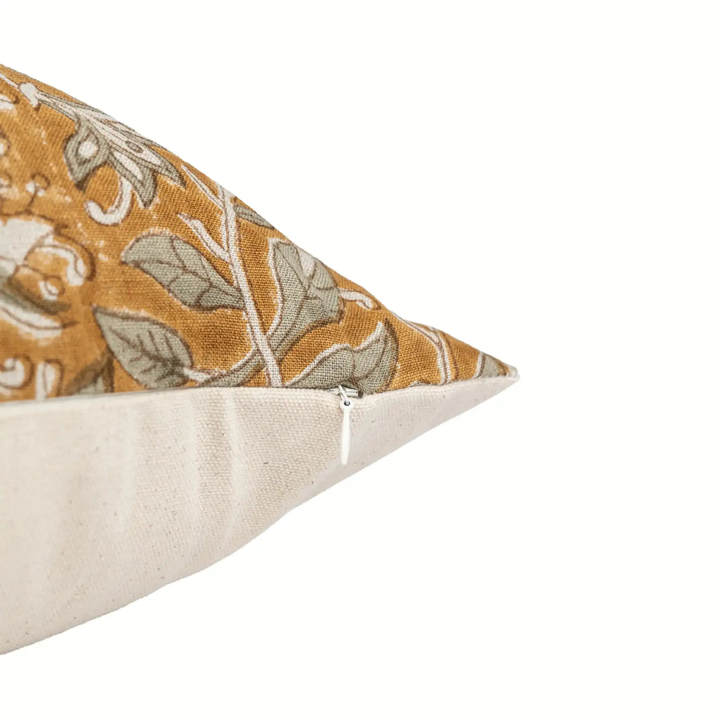 Mustard linen pillow cover with hand-blocked pale green floral vines and a concealed zipper closure.
