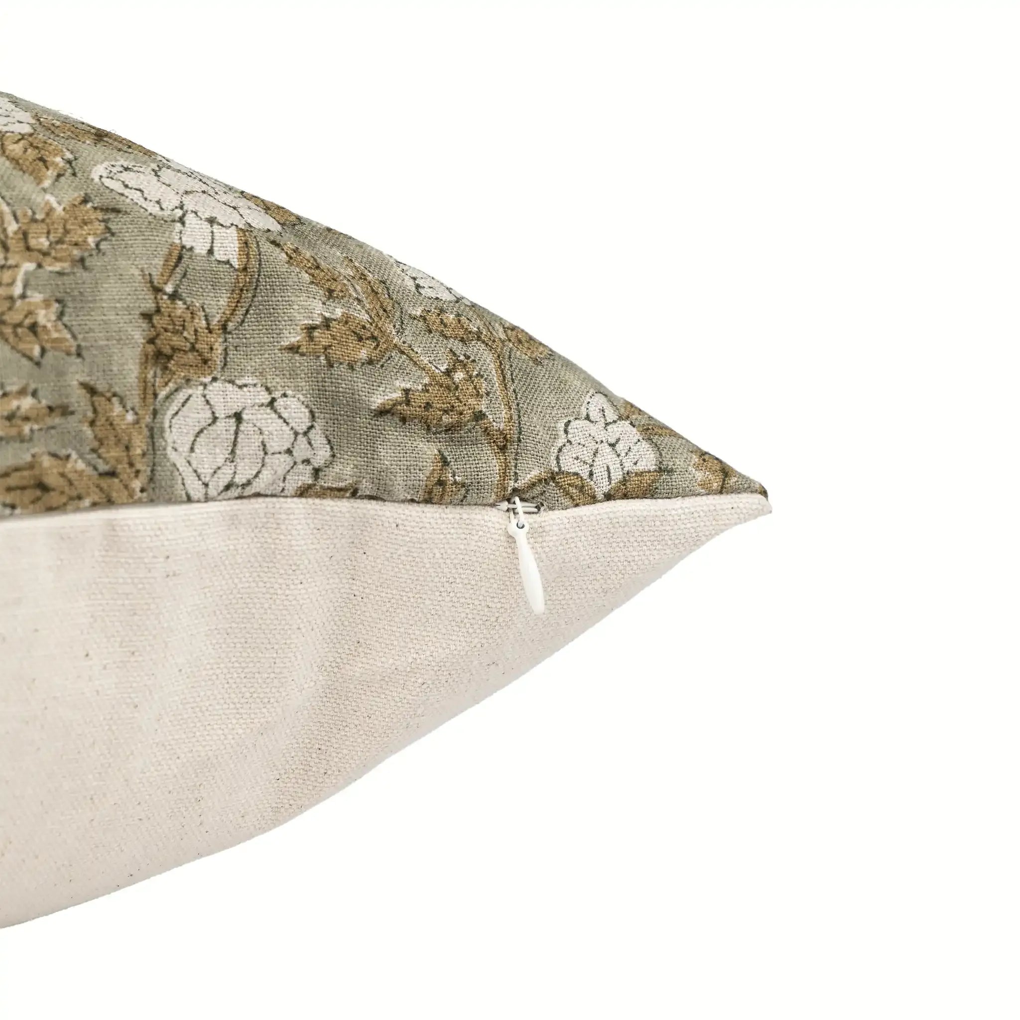 Pale green linen pillow cover with beige and olive floral block print and a discreet white zipper closure.