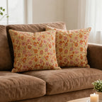 Hand block printed lemon yellow linen pillow covers featuring orange and dusk orange floral vine patterns on a sofa.