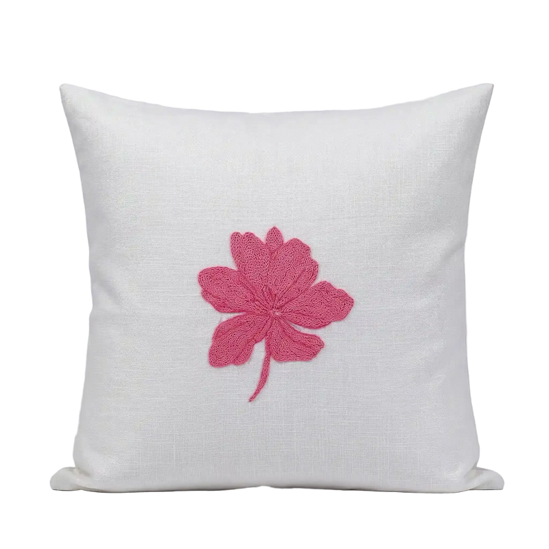 White cotton slub cushion cover featuring a centered, salmon pink embroidered wildflower botanical design.