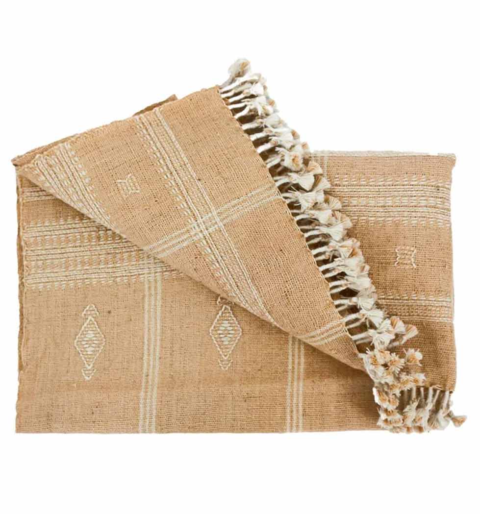 Beige woven blanket with geometric patterns and tassels on a white background