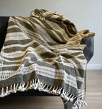 Textured blanket with geometric pattern draped over a chair against a neutral background