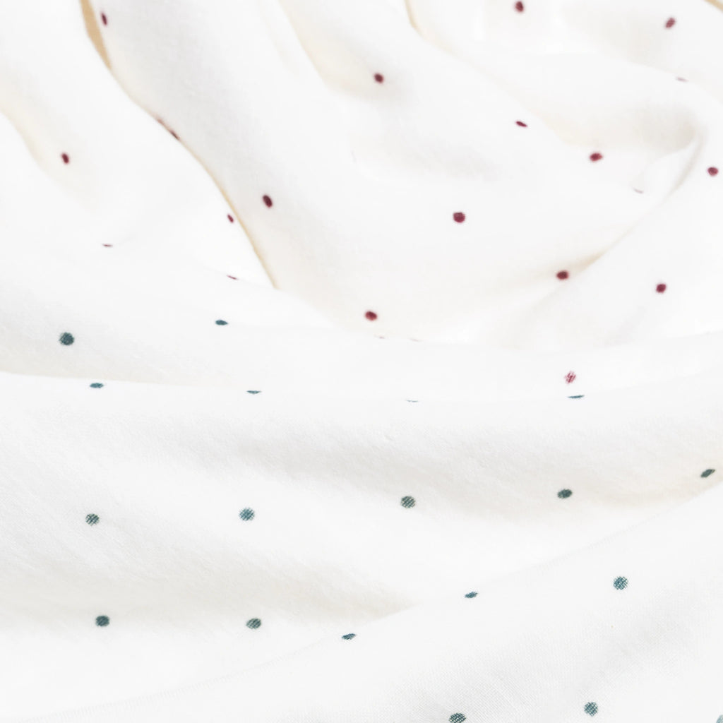 Close-up of a white fabric with small red and green polka dots.