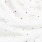 Close-up of a white fabric with small red and green polka dots.
