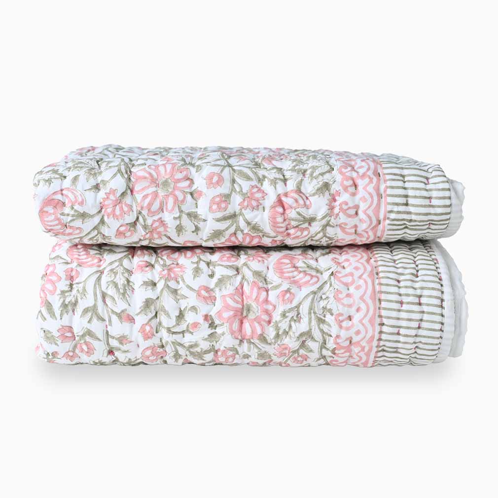 Stack of floral-patterned pillows on a white background