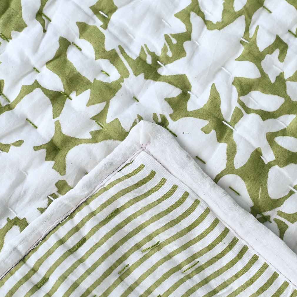 Close-up of green and white patterned fabric with star and stripe designs.