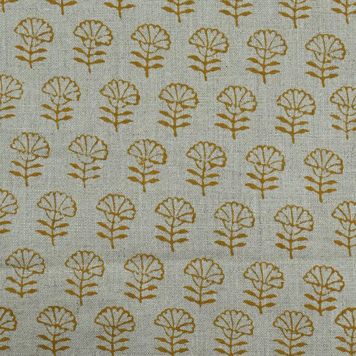 Patterned fabric with gold leaf design on a beige background