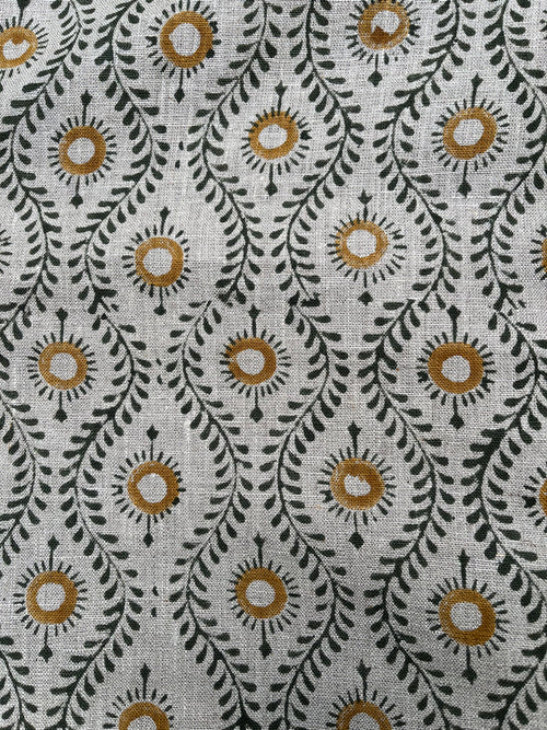 Textile with a floral pattern featuring circles and leaves on a neutral background