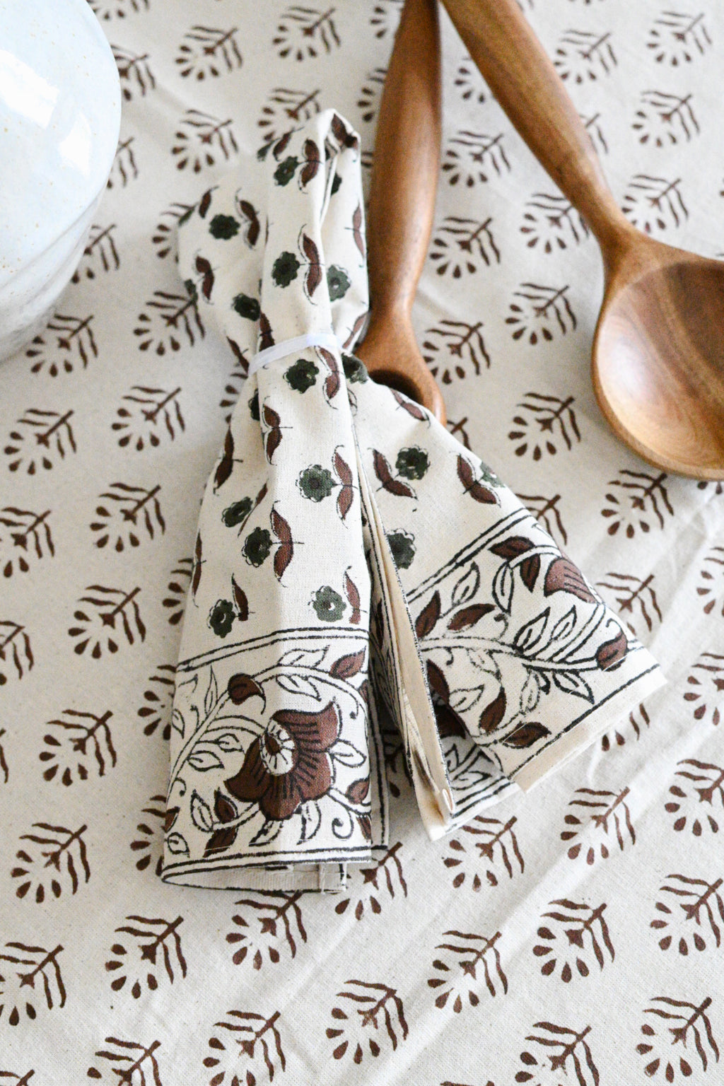 Hand block printed cotton napkins in brown styled on a dining table