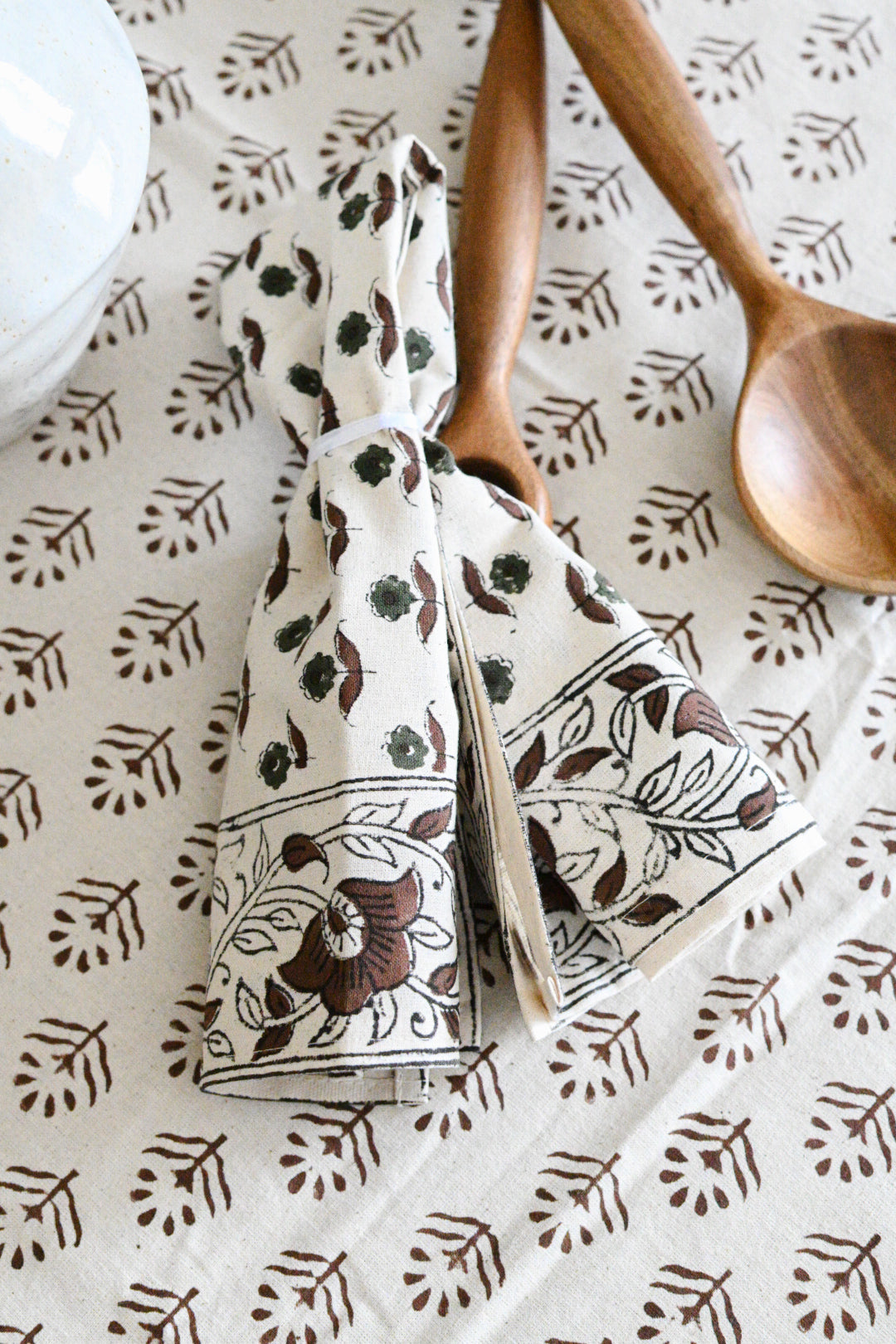 Hand block printed cotton napkins in brown styled on a dining table
