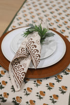 Hand block printed cotton napkins in brown styled on a dining table