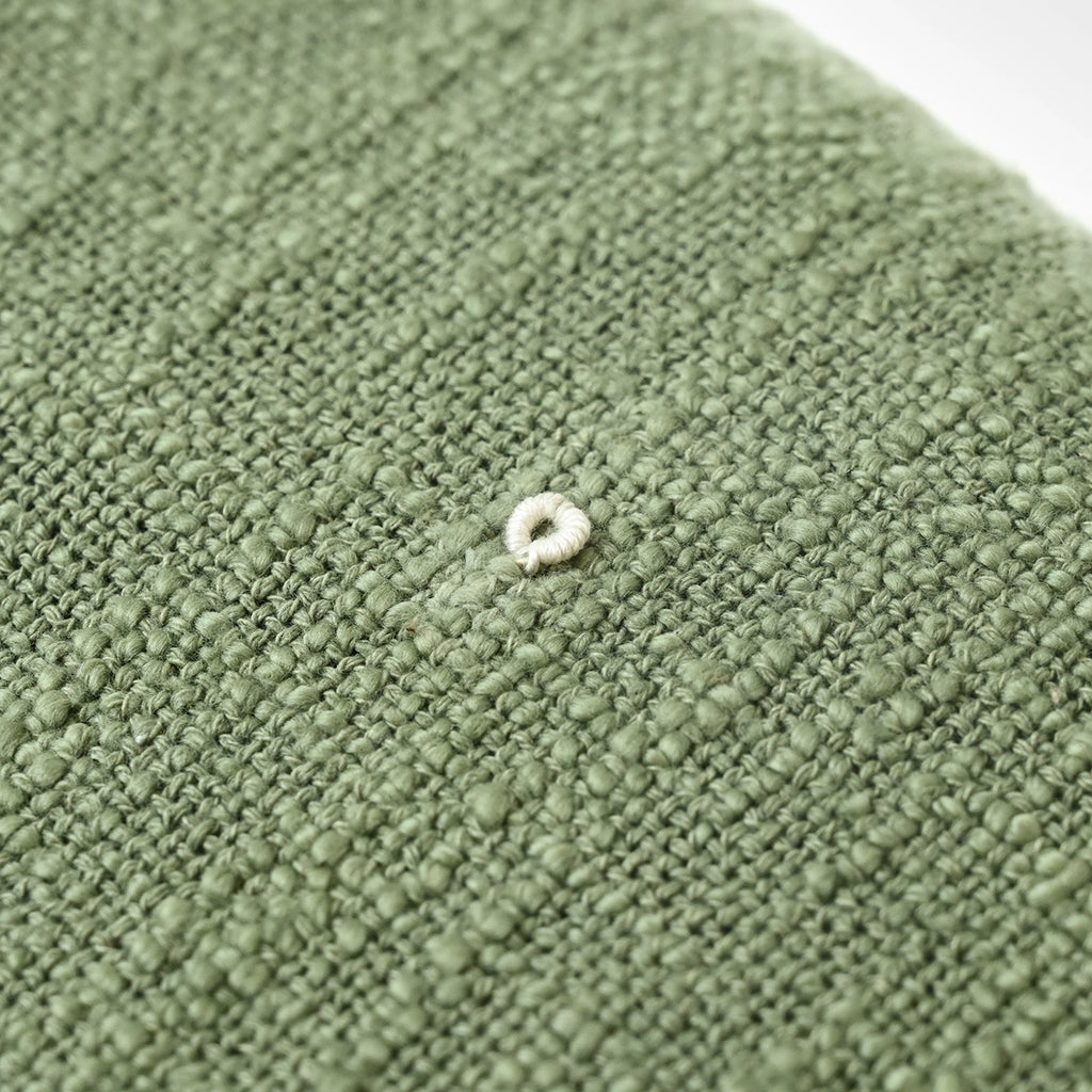 Close-up of a textured green throw blanket surface
