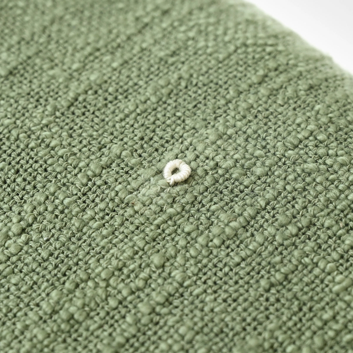 Close-up of a textured green throw blanket surface