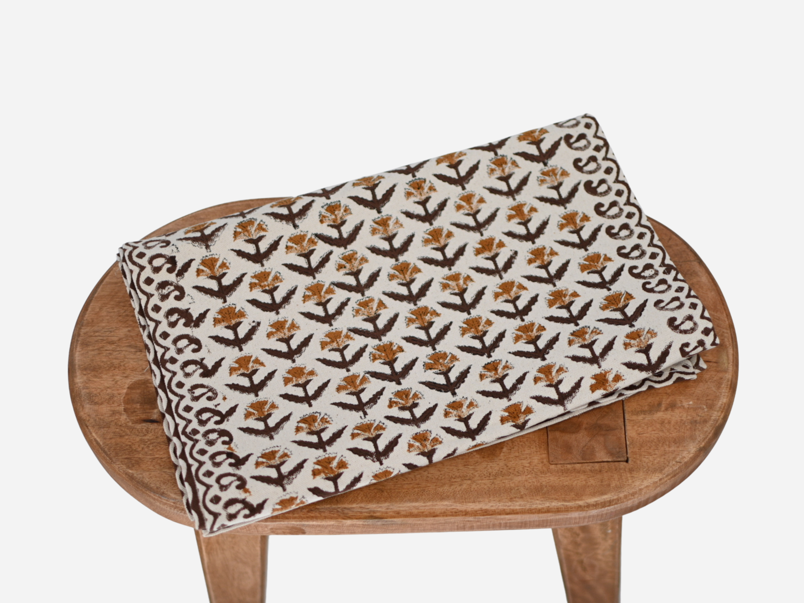 Close‑up of amber gold floral buti block print on cotton‑linen table runner