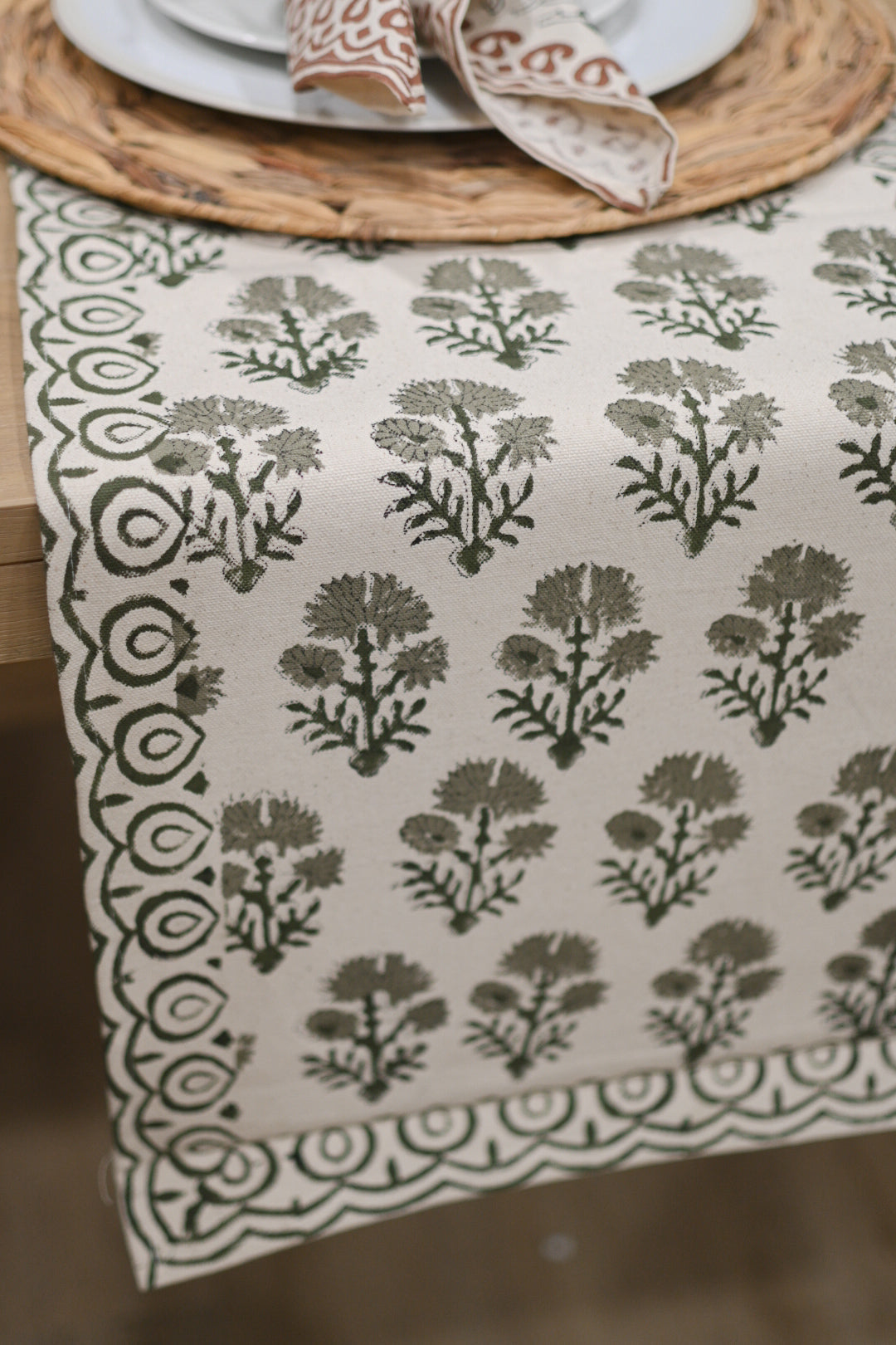 Close‑up of sage green floral buti block print on cotton‑linen table runner