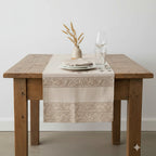 Decorative block print table runner with pom‑pom trim styled on a dining table