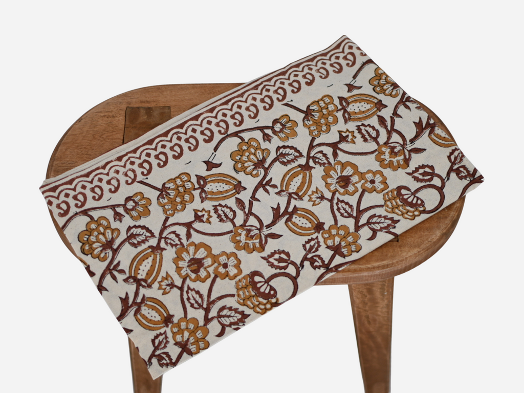 Close‑up of amber gold floral block print on cotton‑linen table runner